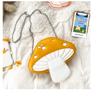 Detail of yellow mushroom crossbody bag with silver chain strap on lace decor