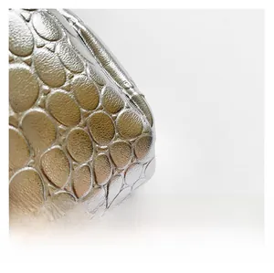Detailed macro view of silver metallic textured crocodile pattern with shiny pebble finish