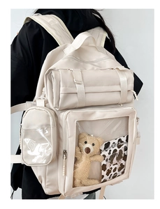 Detail of white ita bag showing transparent display window and multiple zip compartments