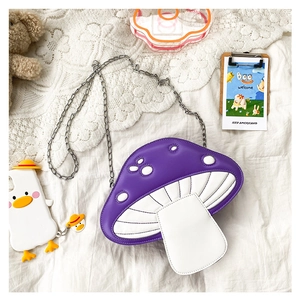 Detail of cute purple mushroom crossbody bag with silver chain strap and polka dot design