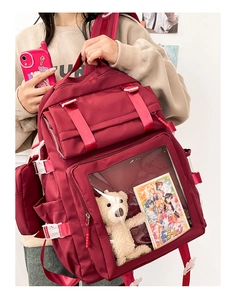 Detail of burgundy ita bag with clear PVC window showing internal decorations and straps