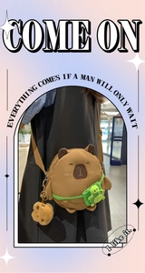 Detail of Capybara plush crossbody bag featuring a small green turtle accessory