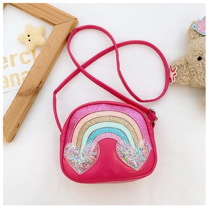 Detail of pink PU leather kids crossbody bag featuring sequined rainbow and heart charms