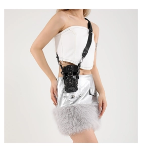Detail of a mini punk crossbody bag with silver studs and metal ring accents