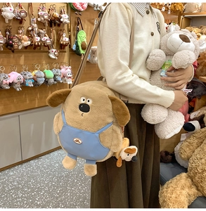Detail of cute plush dog backpack featuring blue overalls and matching mini charm