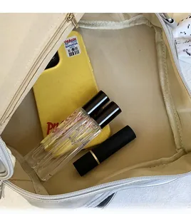 Gros plan sur le compartiment intérieur spacieux du sac à bandoulière en toile beige