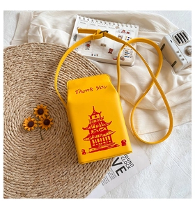 Detailed top view of a yellow takeout box style crossbody bag with sunflower decor