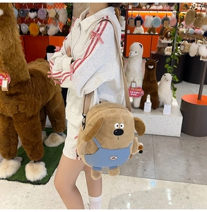 Detailed close-up of a cute brown plush dog shoulder bag with blue overalls worn by a model