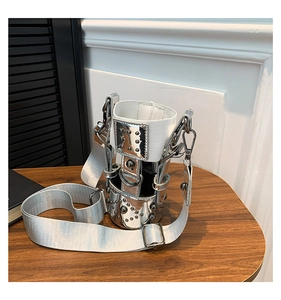 Close-up of silver metal cup bag with rivets and adjustable woven crossbody strap