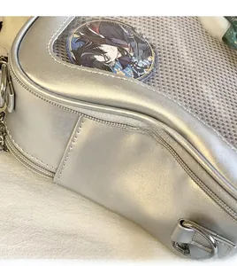 Vue macro d'un sac argenté en similicuir avec fenêtre transparente et couture précise