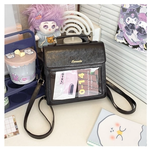 Detailed view of black textured leather bag with clear display window and golden logo
