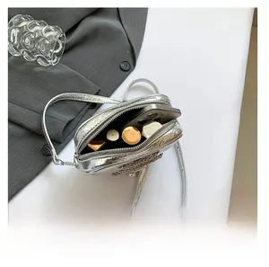 Détail de l'intérieur d'un mini sac argenté montrant la capacité pour smartphone
