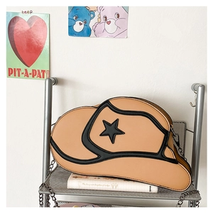 Detailed close-up of a cowboy hat shaped crossbody bag with star decor and chain strap