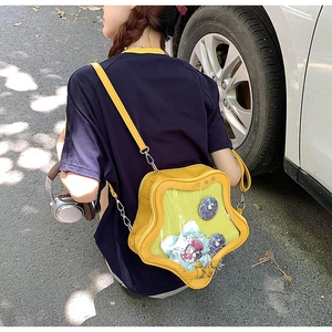 Star-shaped yellow ita bag with transparent window for anime pins worn by model