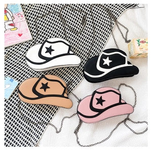 Flat lay of four cowgirl hat shaped mini crossbody bags with metal chains and star details