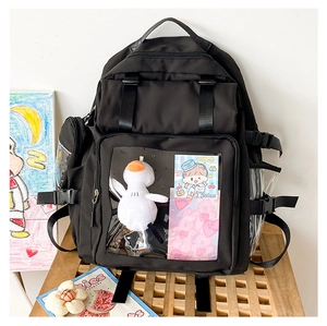 Detail view of black nylon backpack featuring a transparent display window with plush duck