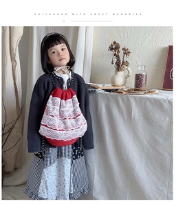 Détail du sac à dos enfant en coton rouge avec dentelle florale blanche et cordons