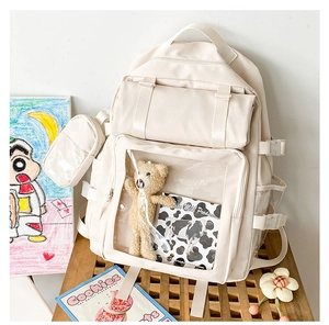 Detailed view of creamy white school backpack with transparent window and plush bear accessory