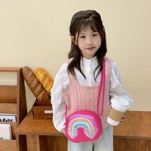 Pink kids crossbody bag with rainbow sequins and glitter hearts worn by a girl