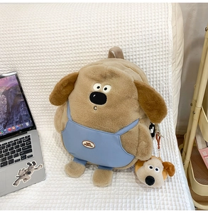 Detail of plush Gromit backpack with blue overalls and matching hanging charm