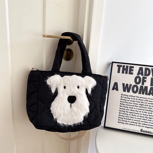 Detail of black quilted crossbody bag with a 3D plush dog design and detachable strap