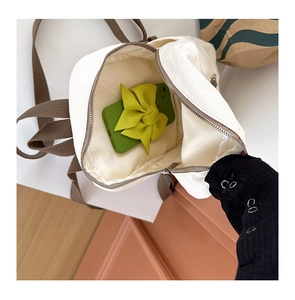 Detail view of the mini canvas backpack interior showing zipper pocket and inner lining