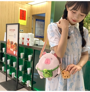 Détail du sac bandoulière peluche capybara rose avec poupée tortue et clip métallique