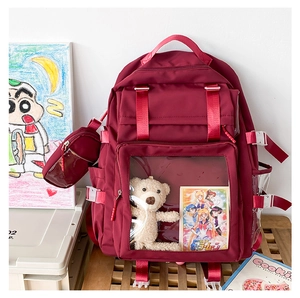 Detail view of burgundy ita-bag with transparent window and side hanging coin pouch