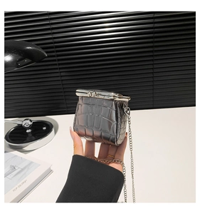 Detail view of silver mini faux leather crossbody bag with stone pattern and chain strap