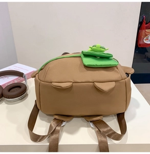 Detail of cute brown capybara backpack with a green mini pouch on the shoulder strap