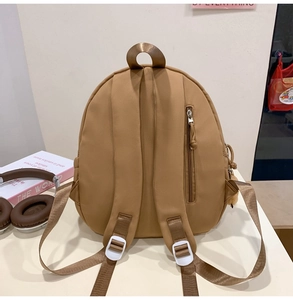 Detailed back view of camel nylon backpack with adjustable straps and anti-theft zipper