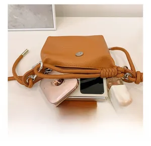 Détail de l'intérieur du mini sac bandoulière marron avec téléphone et cosmétiques