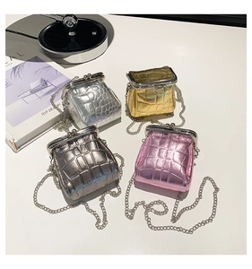 Detail of four colorful mini crossbody bags with crocodile texture and metal chains
