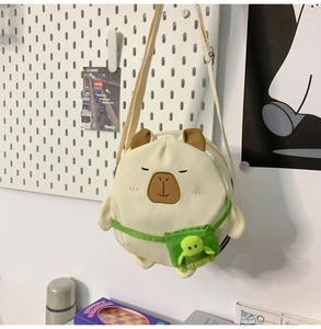 Detail of plush capybara crossbody bag with a cute turtle doll and embroidery