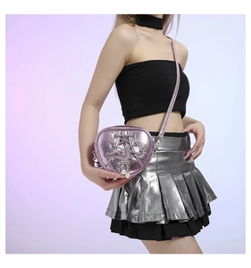 Détail du sac en forme de cœur rose métallisé avec chaînes et breloques en perles