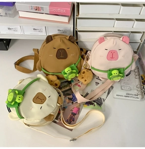 Detail of Capybara plush crossbody bags with embroidery and small turtle charms