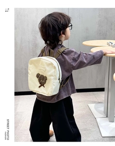 Close-up of cute bear embroidery and bow detail on toddler canvas backpack