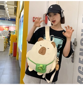 Detail of cute capybara backpack with embroidery and plush turtle charm accessory