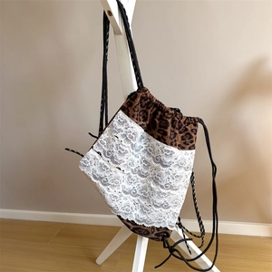 Détail du sac à dos léopard avec des volants en dentelle blanche et cordons noirs