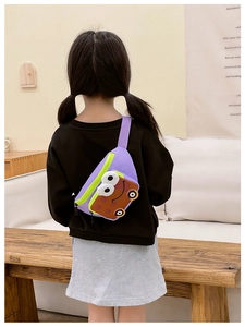 Détail du sac enfant violet avec de grands yeux porté par une fille à l'intérieur