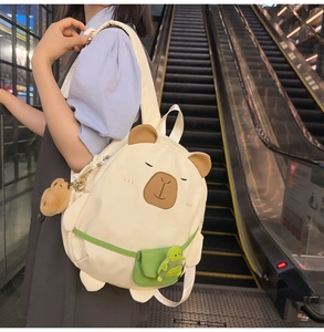 Girl wearing a cute capybara backpack with a small turtle charm in a shopping mall