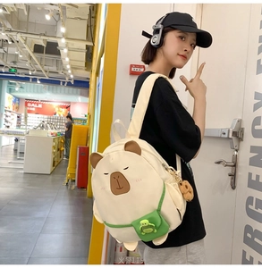Detailed side view of a cute capybara backpack with 3D ears and plush pendant on model