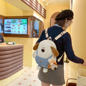 Cute white plush dog backpack with brown ears and blue overalls featuring matching charm