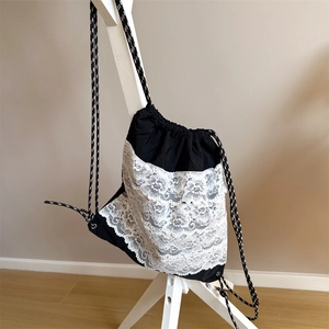 Détails des couches de dentelle blanche sur le sac à dos en toile noire pour enfants
