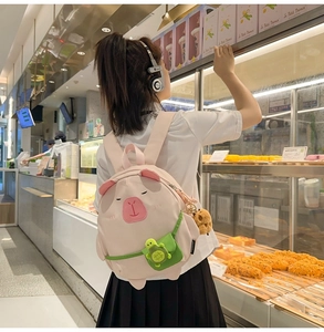 Cute pink pig-shaped backpack with a detachable green turtle coin purse charm detail