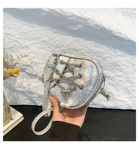 Détail du sac bandoulière argenté irisé avec laçage par chaîne et perles blanches