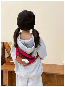 Sac banane rouge pour enfant avec motif voiture mignonne porté dans un décor lifestyle