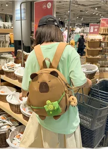 Detail of cute brown capybara plush backpack with green turtle pocket and durable canvas texture