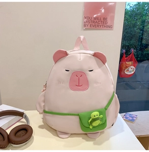 Close-up of pink capybara backpack with 3D ears and cute turtle plush pendant detail