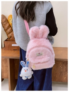 Détail d'un sac à dos lapin en peluche rose avec oreilles douces et porte-clé lapin